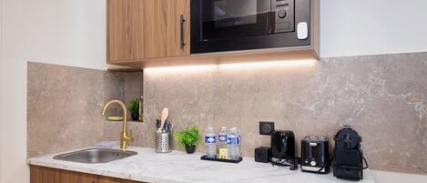 A kitchen with a built-in microwave, a sink, and various appliances.