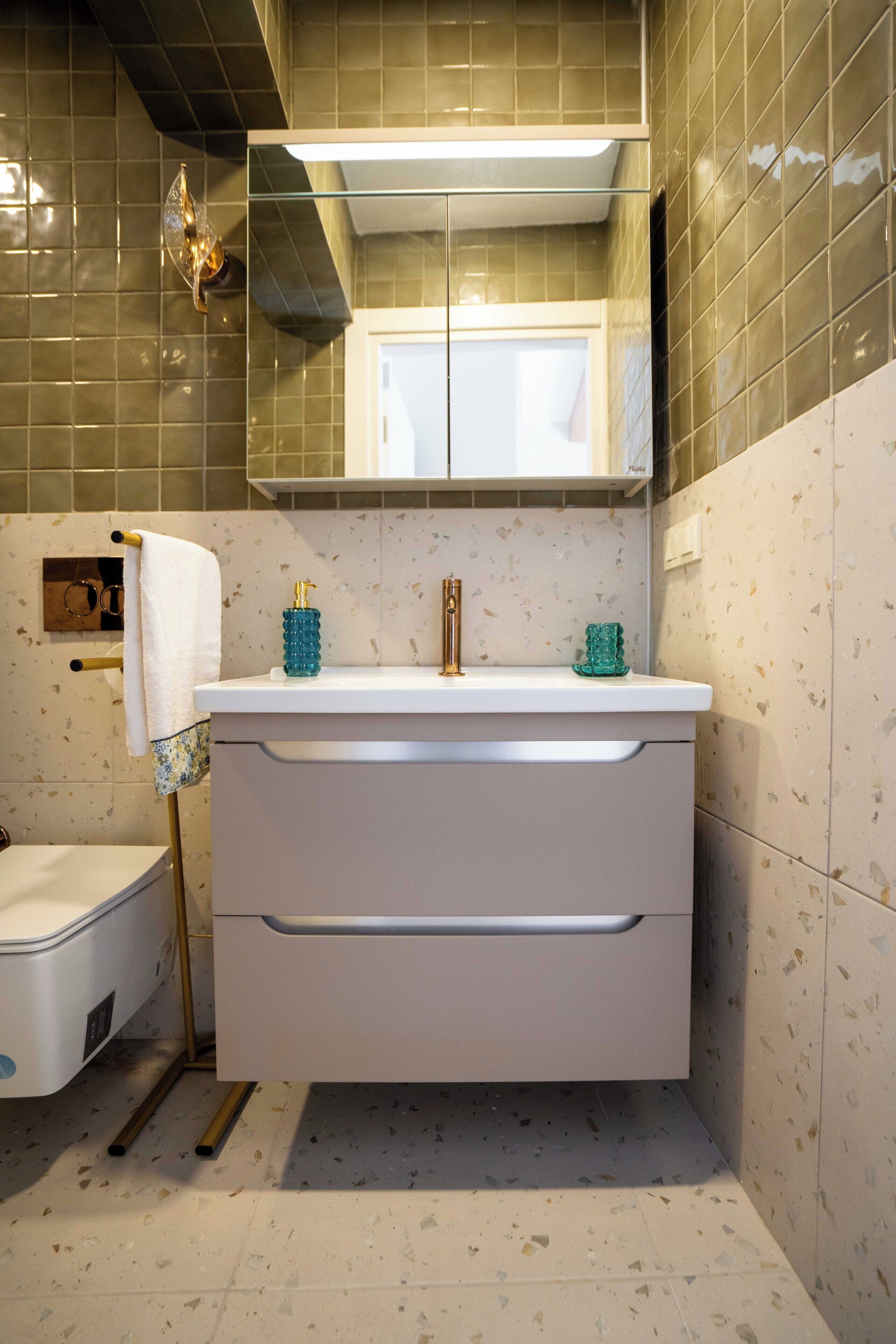 A bathroom with a white vanity, a towel rack, a glass shower enclosure, and a toilet.