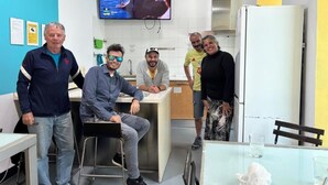 Une cuisine moderne équipée d’un téléviseur à écran plat, d’un réfrigérateur et d’un coin bar.