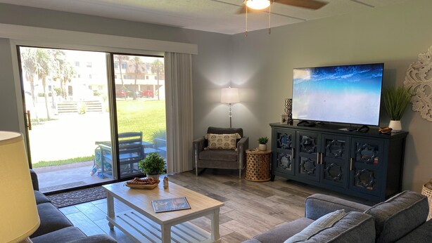 Un salon comprenant un canapé, une table basse, un téléviseur et un meuble.