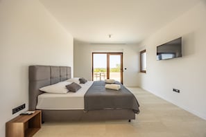 A modern bedroom with a large bed, a TV mounted on the wall, and a sliding glass door leading to an outdoor area. - Villa Cvita Poličnik Zadarvillas (Policnik)