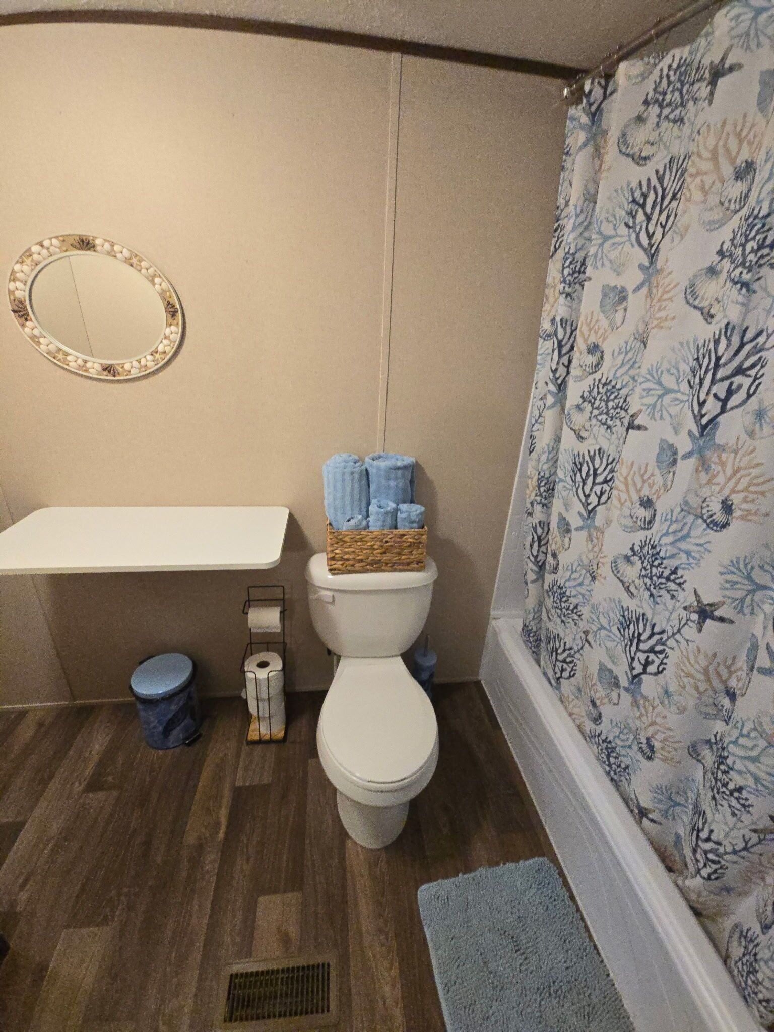 Ein Badezimmer mit Toilette, Waschbecken, Spiegel und Duschvorhang.