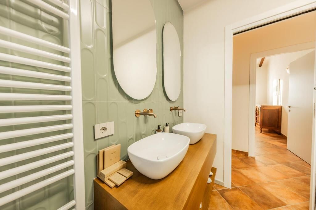 A bathroom with two sinks, a towel rack, and a mirror.