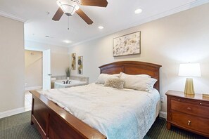 Ein Schlafzimmer mit einem hölzernen Bett, einem Nachttisch, einem Deckenventilator und einem Wandbild.