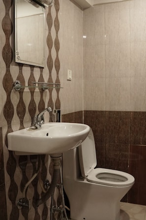 A bathroom with a sink, mirror, and toilet. - Hotel Terracotta (Bhaktapur)