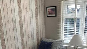 Ein Schlafzimmer mit zwei Einzelbetten, einem Nachttisch mit Lampe und einem Bild an der Wand.