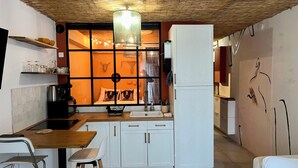 Une cuisine compacte dotée d’un îlot central, d’une machine à café et d’un évier.