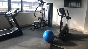 A gym with a treadmill, elliptical, weight machine, and exercise ball. - Santiago Retreat EXC Modern 1 BR Apartment in Las Condes (Santiago)