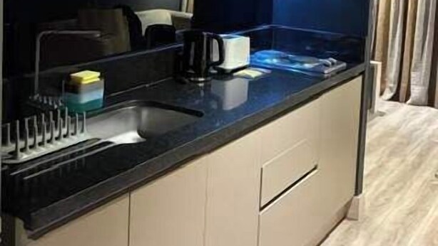 A modern kitchen with a black countertop, beige cabinets, and a microwave. - Santiago Retreat EXC Modern 1 BR Apartment in Las Condes (Santiago)