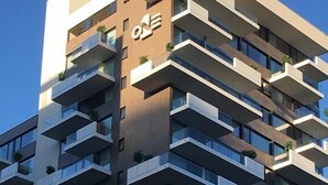A multi-story building with a modern architectural design, featuring balconies on each floor. - Santiago Retreat EXC Modern 1 BR Apartment in Las Condes (Santiago)