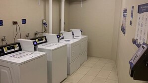 A laundry facility with industrial washers and dryers, a tiled floor, and a ceiling with fluorescent lighting. - Santiago Retreat EXC Modern 1 BR Apartment in Las Condes (Santiago)