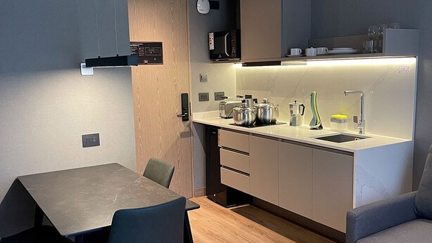 Une cuisine moderne avec un coin repas comprenant une table, des chaises et un four à micro-ondes.