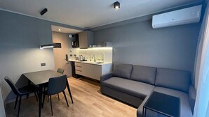 Un espace de vie compact comprenant un coin repas, une kitchenette et un coin salon.