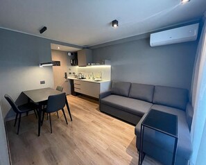 A compact living space with a dining area, kitchenette, and seating area.