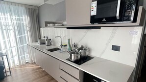 Eine moderne Küche mit Mikrowelle, Herd, Spüle und Schränken.