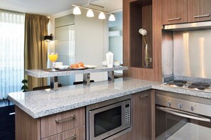 A modern kitchen with granite countertops, stainless steel appliances, and a built-in microwave.