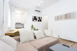 Ein modernes Hotelzimmer mit Bett, Schreibtisch, Stuhl, einer Pflanze und Bildern an den Wänden.