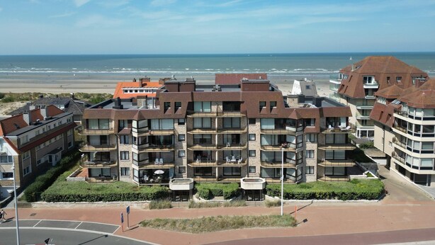 Ett hotell med flera våningar, balkonger, utsikt över stranden och en vackert anlagd innergård.