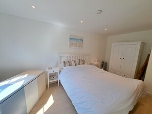Ein Schlafzimmer mit Bett, Nachttisch und Kleiderschrank.