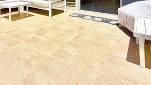 Eine Terrasse mit einer weißen Couch, einem weißen Tisch und einer weißen Bank.