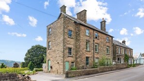 A stone building with multiple windows and a flat roof.