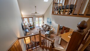 A spacious living area with a high ceiling, a dining table, and a staircase leading to an upper level. - OG22 - An Eagle Ridge Resort & Spa Rental with Full Resort Amenities and Owners Club Access! (Galena)