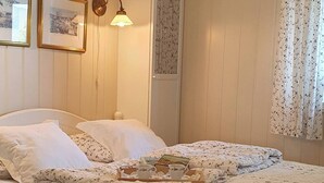 A bedroom with a bed, a nightstand, a lamp, a wardrobe, and a window with curtains. - Serene Fjord View Holiday House in Davik, Nordfjord (Bremanger)