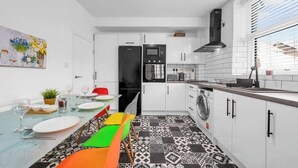 Una cucina moderna completa di frigorifero, forno a microonde, forno e lavatrice.