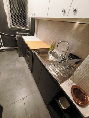 A modern kitchen with a stainless steel sink, a wooden countertop, and a dish rack. - Apartment F2 (living room + one bedroom) approx. 45m (București)