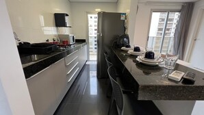 Una cocina moderna con refrigerador, estufa y microondas.