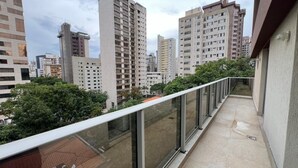 Balcón con vistas a edificios altos y zonas verdes.