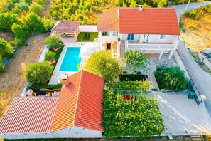A two-story house with a swimming pool, a covered patio, and a garden. - Holiday Home Dinko with pool (Pridraga)