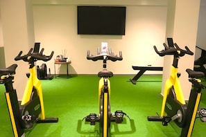 A room with three stationary bikes, a flat-screen TV on the wall, and a small table with items. - In a Residence, Air-conditioned, Large Outdoor Space (Marone)
