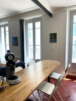 Ein Essbereich mit Holztisch, Stühlen, einer Kaffeemaschine und einem Fenster mit Aussicht.