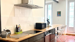 Eine moderne Küche mit einer zentralen Kochinsel, Edelstahlgeräten und einem großen Fenster.