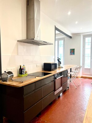Eine moderne Küche mit einer zentralen Kochinsel, Edelstahlgeräten und einem großen Fenster.