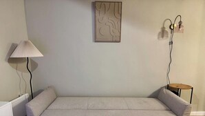 A room with a bed, a lamp, a wall art piece, and a small table with a chair. - Comfortable apartment in the heart of the city (Toulon)