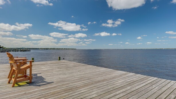 A wooden pier extending into calm water with a clear sky. - Poolside Fun! Waterfront Gem Near San Marco Square (Jacksonville)