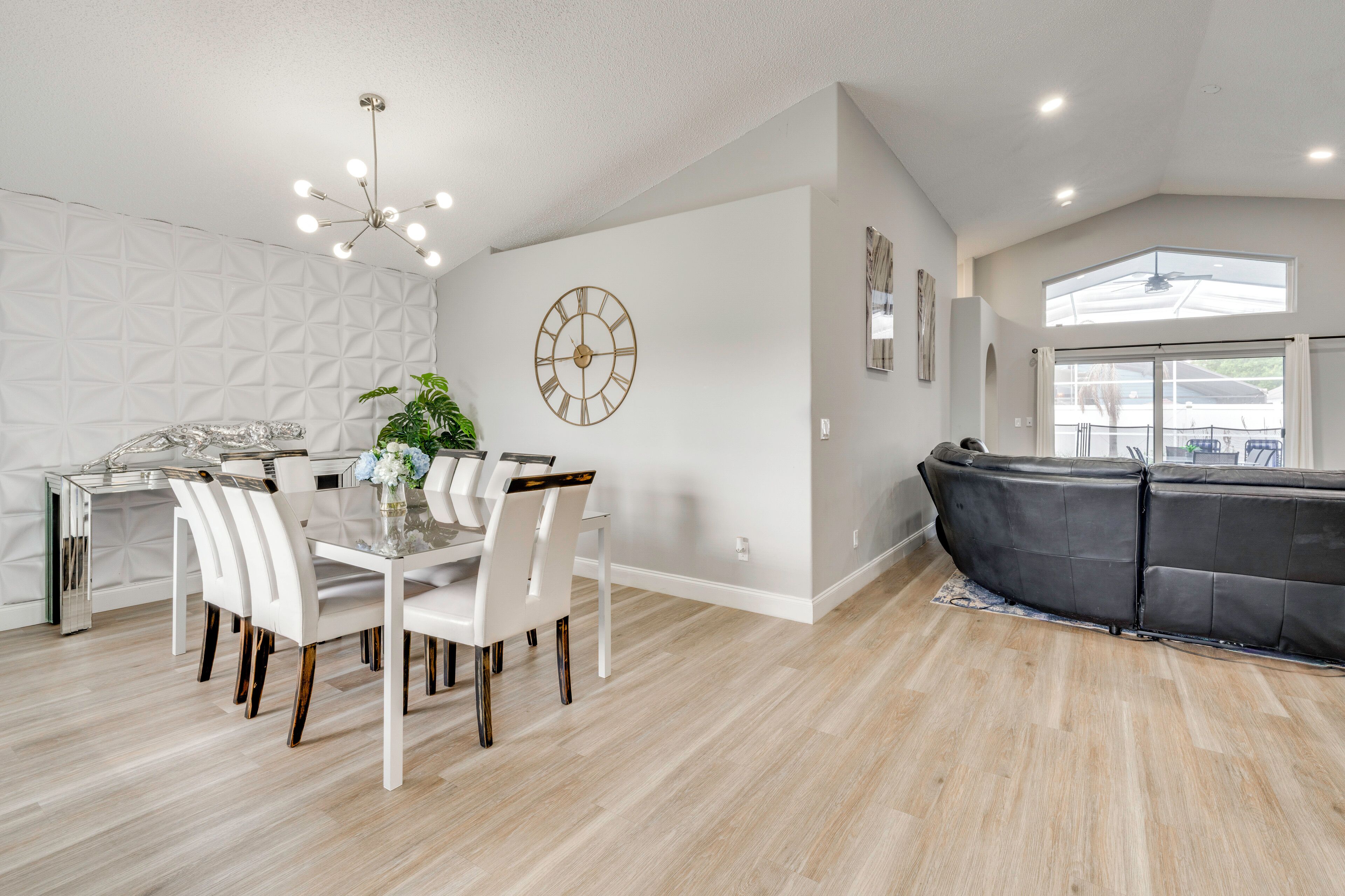 Une cuisine moderne avec une table à manger, des chaises et une horloge au mur.