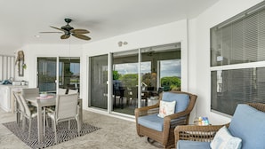 A room with a dining table, chairs, a wicker sofa, and a ceiling fan. - Spectacular Views! Largest Canal in NW Cape Coral (Cape Coral)