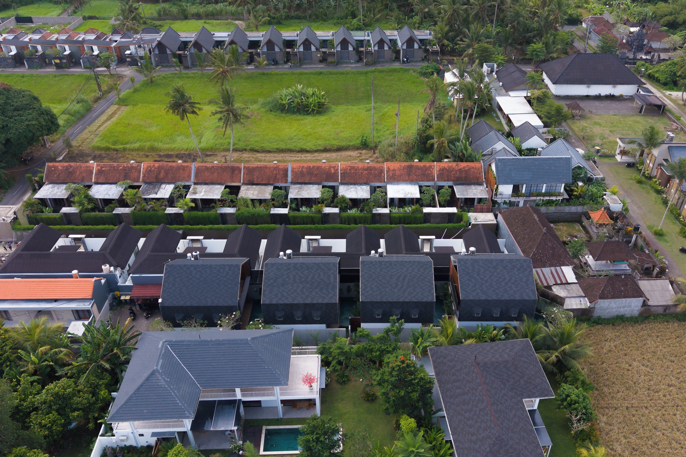 A residential area with multiple houses, some with flat roofs and others with sloped roofs.