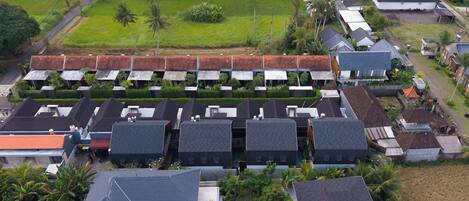 A residential area with multiple houses, some with flat roofs and others with sloped roofs.