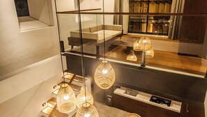 A modern interior with a sofa, dining table, and hanging lights. - Aluna Ubud Villas (Ubud)
