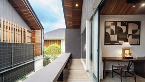 A modern interior with a long bench, a desk, and a chair. - Aluna Ubud Villas (Ubud)