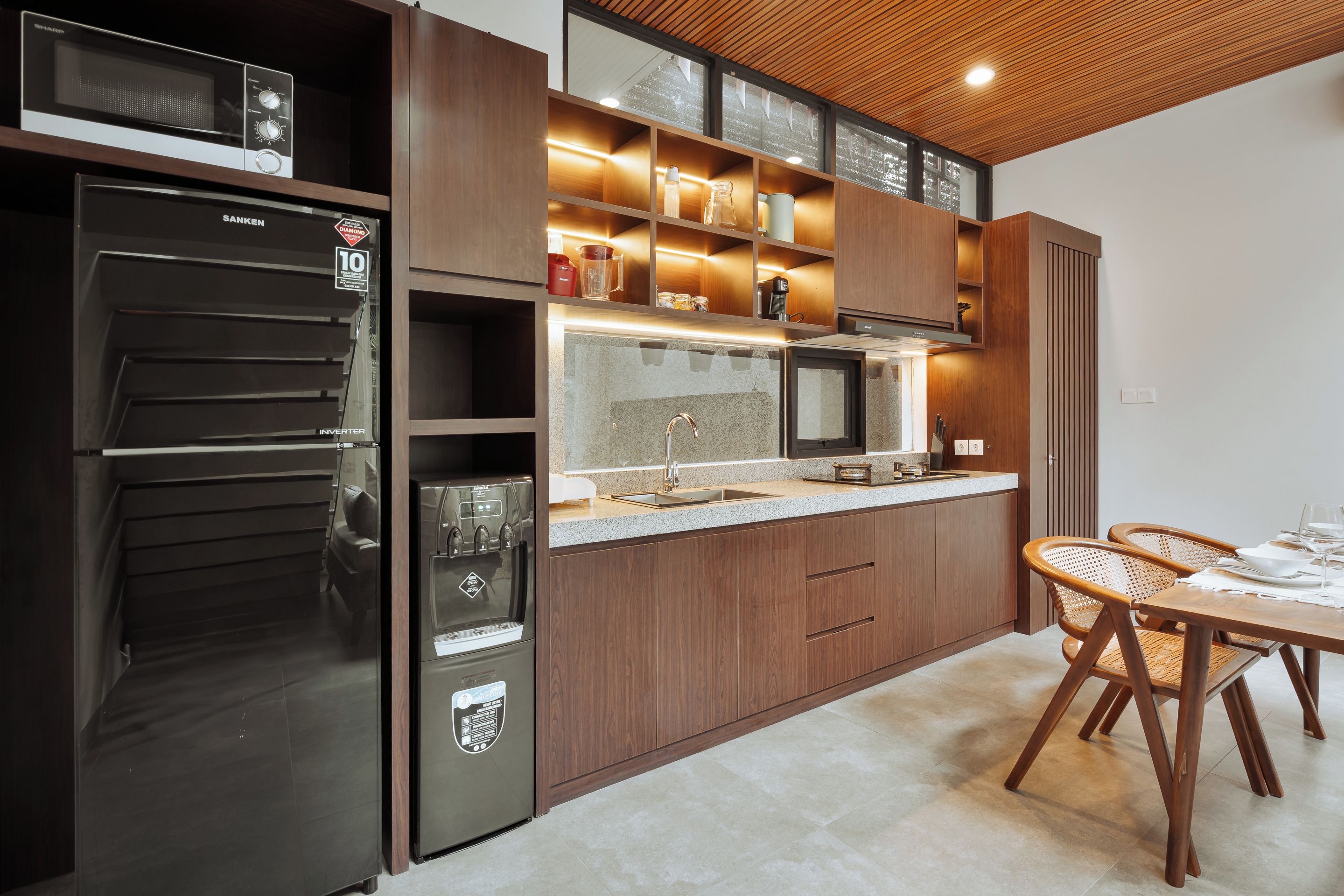 A modern kitchen with a built-in refrigerator, microwave, and stainless steel appliances.