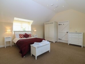 A bedroom with a bed, nightstands, a dresser, a wardrobe, and a window with a view. - Llanallgo Church Rooms (Moelfre)