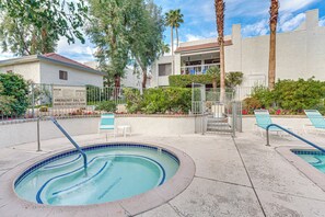 A swimming pool with a hot tub, surrounded by lounge chairs and a building with a sign indicating emergency contact information. - 2 Mi to Dtwn! Chic Palm Springs Condo (Palm Springs)