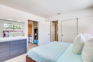Ein Schlafzimmer mit Bett, Kommode und Kleiderschrank.