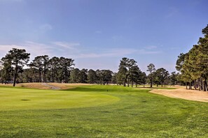 A golf course with a well-maintained green, sand bunkers, and a clear sky. - Pool Access! Myrtlewood Villas Golf Escape (Myrtle Beach)