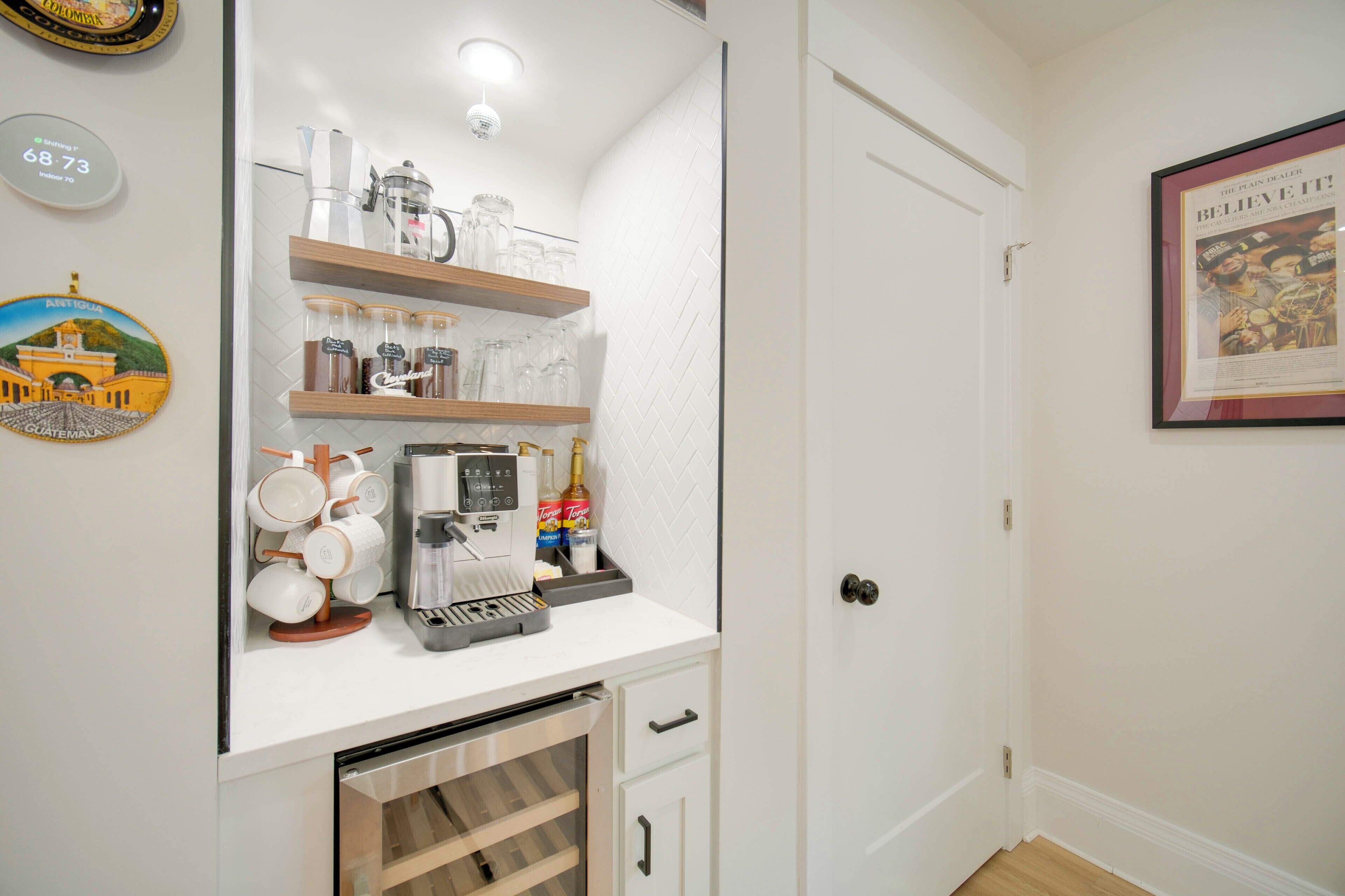 A kitchen with a coffee machine, jars, and a clock.